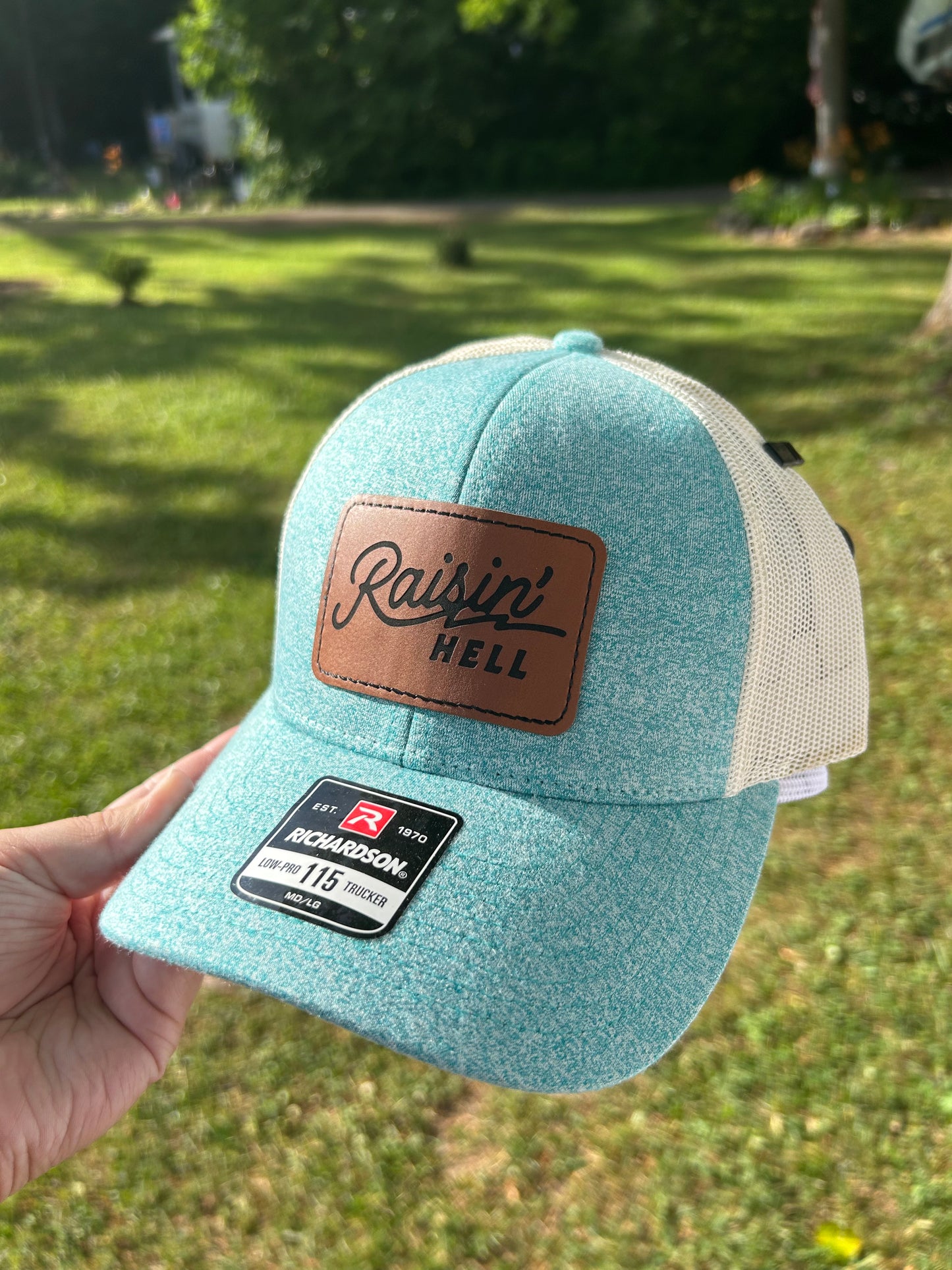 Teal hat with raising hell patch